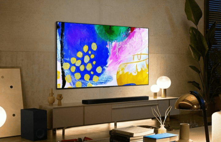 LG B2 OLED 4K 스마트 TV는 거실의 엔터테인먼트 센터 위 벽에 부착되어 있습니다.