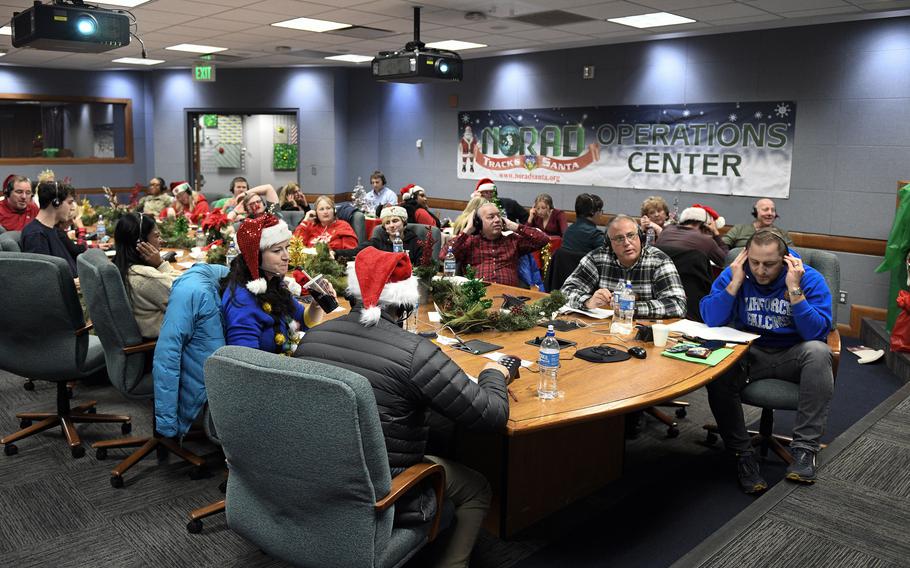 콜로라도주 콜로라도 스프링스에 있는 NORAD 트랙스 산타 운영 센터의 자원봉사자들이 2022년 12월 24일에 전화를 건 사람에게 산타의 위치와 그가 전달한 선물의 개수를 알립니다. 
