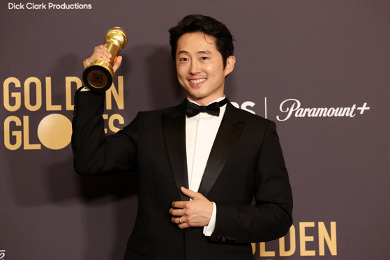 Steven Yeun, winner for Best Performance by a Male Actor in a Limited Series, Anthology Series, or a Motion Picture Made for Television for ″Beef,″ poses with the award at the 81st Golden Globe Awards in Beverly Hills, California, on Monday. [REUTERS/YONHAP]